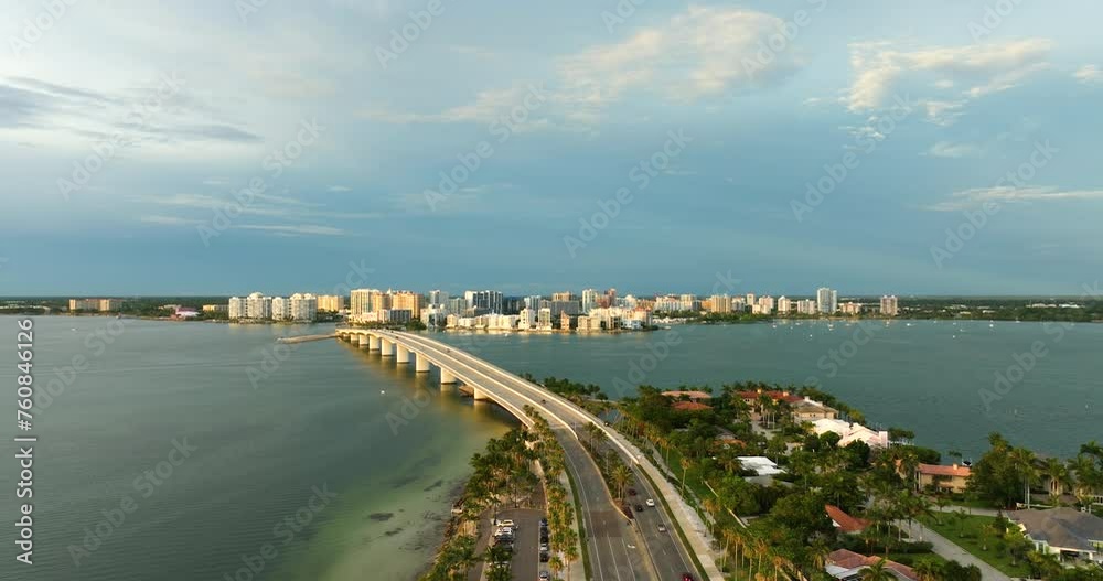 Aerial view of Sarasota city downtown with Ringling Bridge and high-rise office buildings on horizon. Real estate development in Florida. USA travel destination Aerial view of Sarasota city downtown with Ringling Bridge and high-rise office buildings on horizon. Real estate development in Florida. USA travel destination