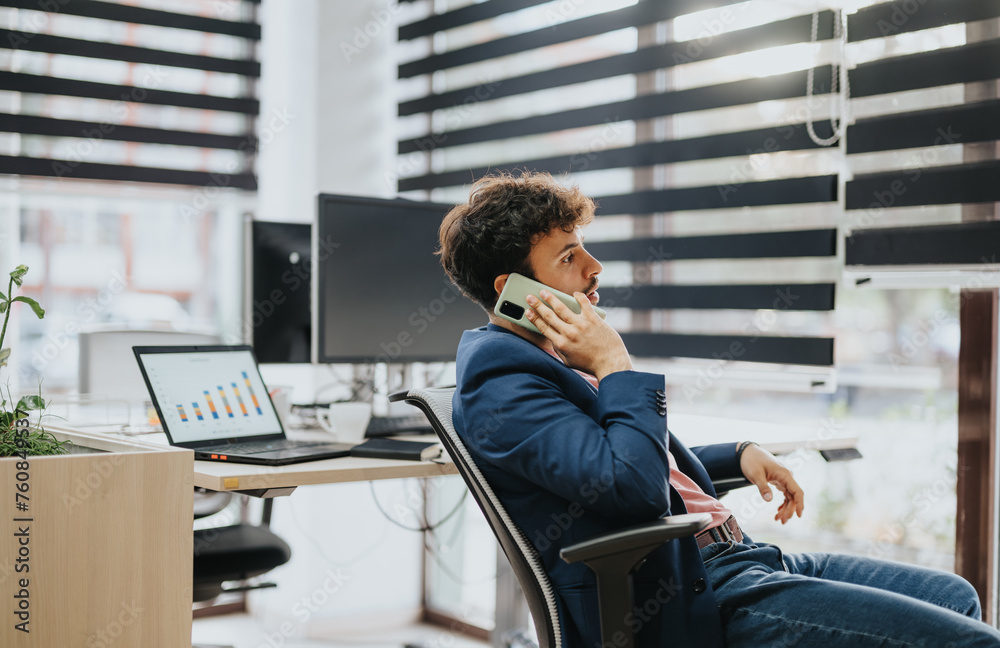 Good looking male employee having phone call at the office. Good looking male employee having phone call at the office.