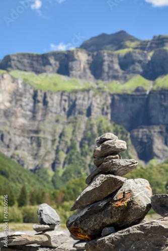 Stack of balancing rocks symbolising peace and mindfulness over a lush mountain landscape