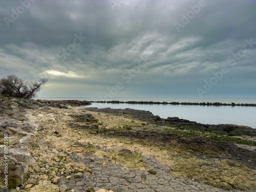 Bord de mer calme avec rochers et ciel nuageux