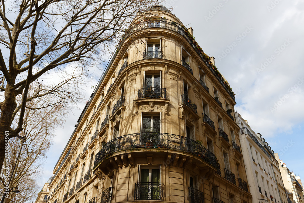 The facade of traditional French house with typical balconies and windows. Paris.