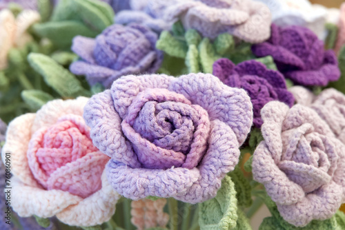 Close up on bouquet of beautiful hand crafted crochet flowers. Colorful roses.