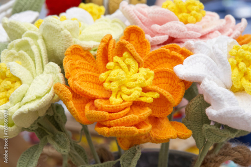 Close up on bouquet of beautiful hand crafted crochet flowers. Orange and yellow flower. © sheilaf2002