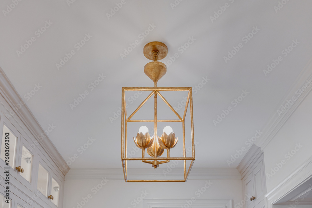 Brass Chandelier Hanging From Ceiling in Luxury Kitchen