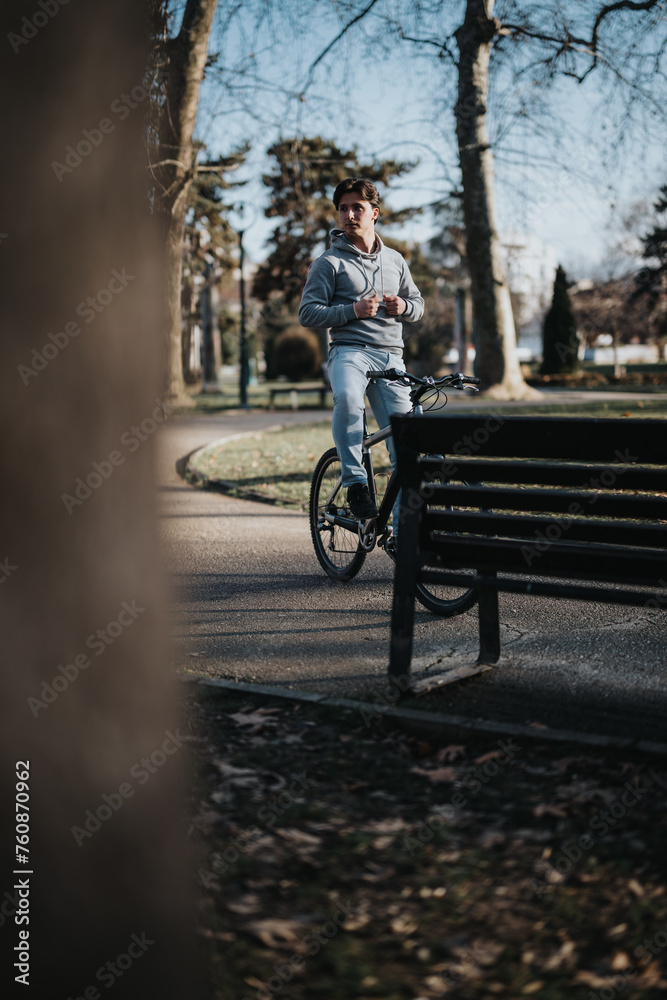 Young adult male leisurely cycling on a clear day, experiencing the tranquility of a green park.