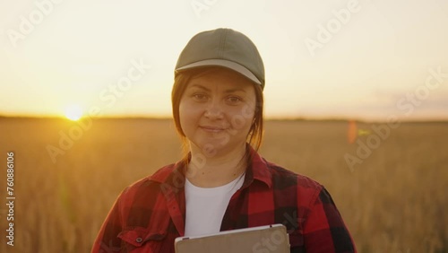 Portrait of a girl agronomist standing in a field smiling looking at the camera
