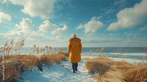 Person Walking in Yellow Coat on Beach