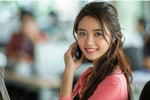Woman Sitting At Desk Talking On Cell Phone