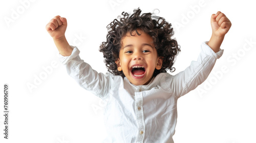 A little boy standing with his arms raised high in the air, expressing pure joy and freedom