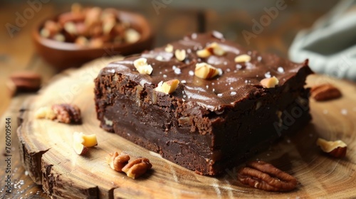 Raw vegan chocolate brownie with nuts on rustic wooden plate. Healthy sweed food concept