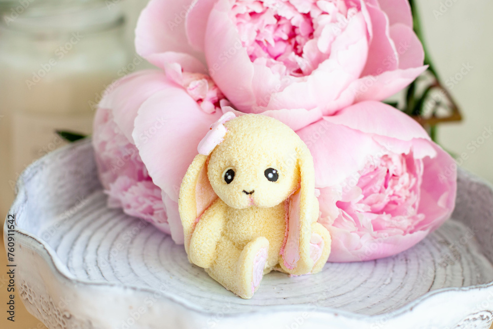 Cute edible bunny made of white chocolate with peony flowers and candles Cute edible bunny made of white chocolate with peony flowers and candles