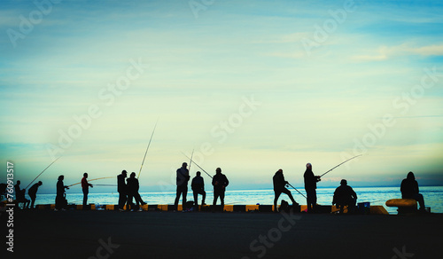 fishermen fishing on harbour at dusk