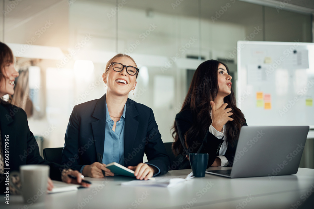 © Flamingo Images - Laughing group of diverse businesswomen talking during an office meeting together