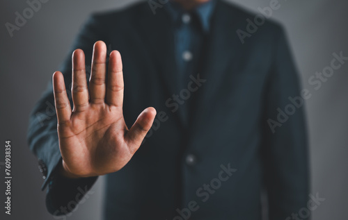 Male hand showing stop gesture, concept of stop violence. Warning, prohibition, denial. On dark background.