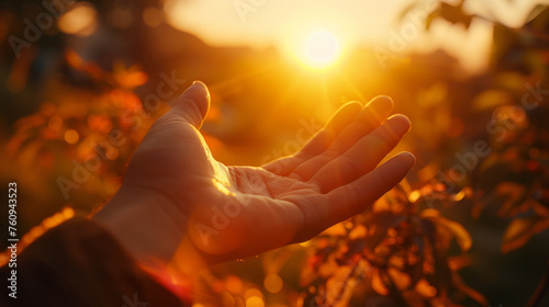 In the serene embrace of twilight, an outstretched hand is bathed in the warm, golden light of a setting sun, with the colours of autumn leaves softly blurred in the background