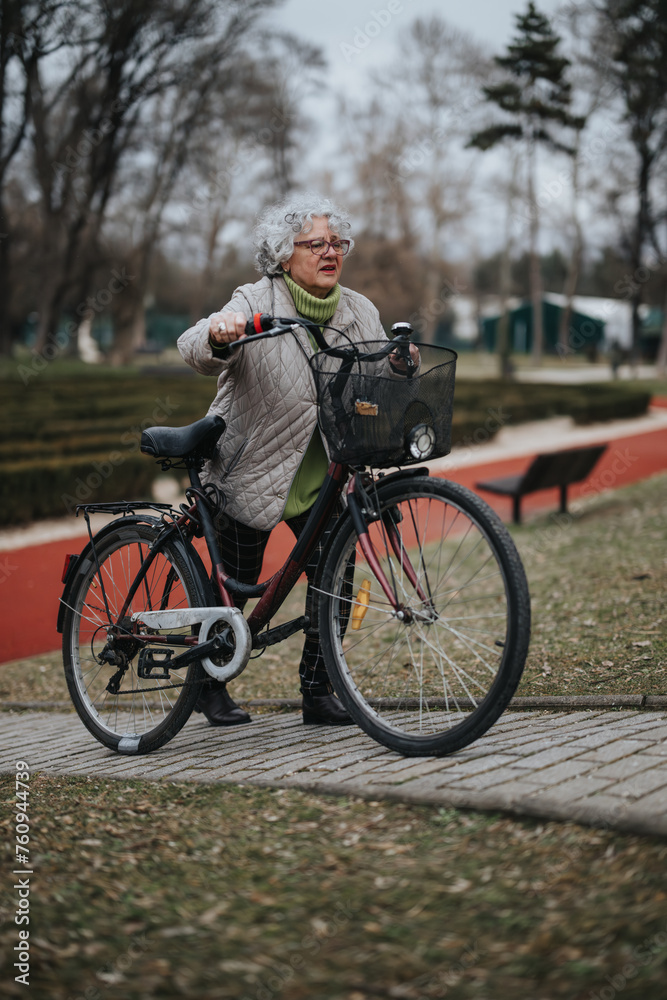 Fototapeta premium Mature female retiree stays fit by cycling, embracing an active lifestyle outdoors.