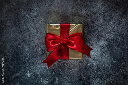 Golden Gift Box With Red Bow On Dark Background