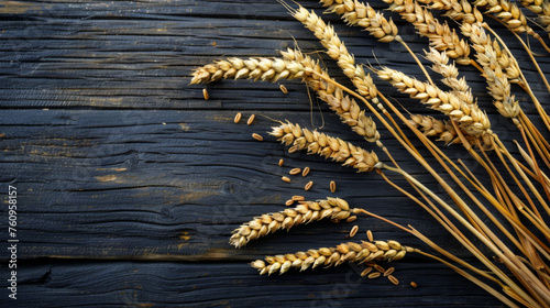 Close-up of a bunch of ripe wheat on a wooden dark background. View from above. Free space for text. Agriculture concept, food.