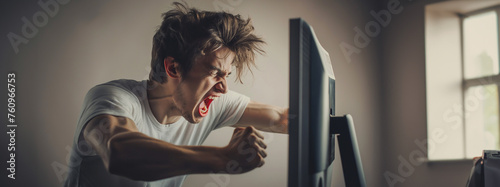 enraged young man punching a computer monitor photo