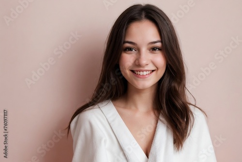 Beautiful young woman with a towel on a smooth pink background with copy space.