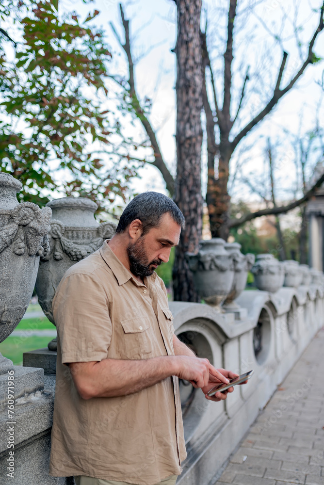 Mid Adult Bearded Man in the City Streets Using his Smart Phone