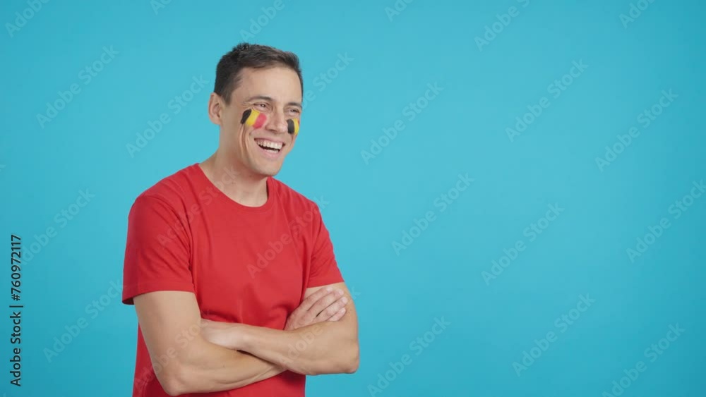 Happy man with belgian flag painted on face looking away Happy man with belgian flag painted on face looking away