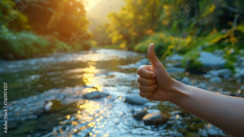 Thumbs up sign. Woman s hand shows like gesture. River background