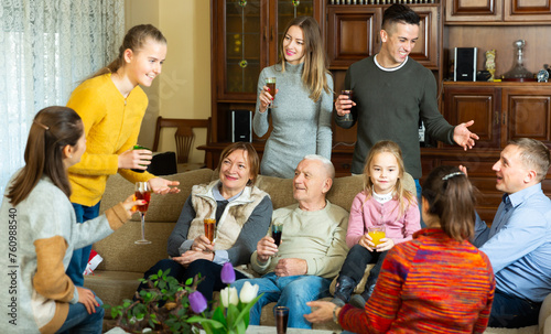 Three generations of happy family carefree communicating in comfortable apartment