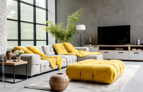Loft interior design of modern living room, home. Tufted grey sofa with yellow pillows and plaid near tv unit and vibrant yellow pouf in room with concrete wall. © Vadim Andrushchenko