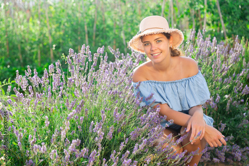 Portrait of European woman near flowers beside lavender shrub