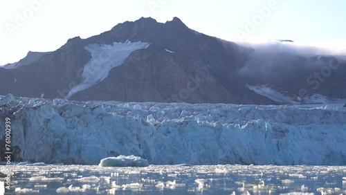 Birds Flying Above Glacier Ice and Glacial Lagoon, Fjortende Julibreen Glacier, Svalbard, Norwegian Northern Territories photo