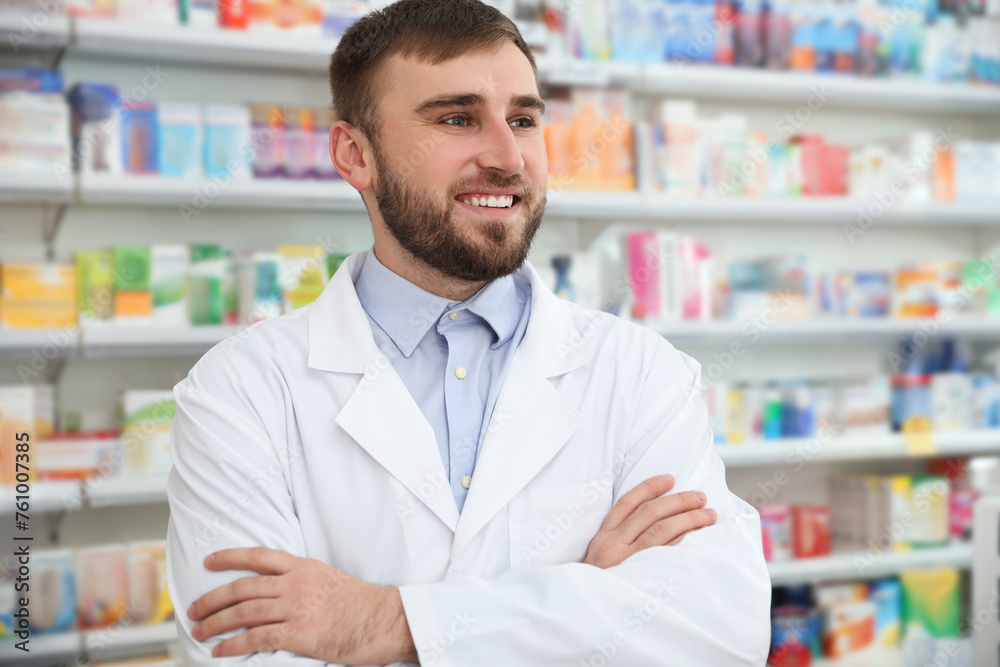 Professional pharmacist with crossed arms in modern drugstore