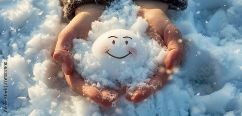 Hands enveloping a perfect paper cut smiling face on a soft, feather-like snow drift, representing the lightness and purity of joy in winter photo