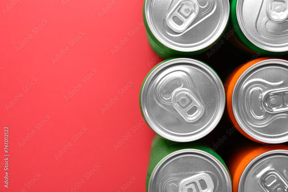 Energy drink in cans on red background, top view. Space for text Energy drink in cans on red background, top view. Space for text