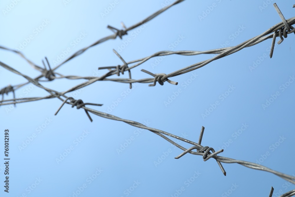 Metal barbed wire on light blue background Metal barbed wire on light blue background