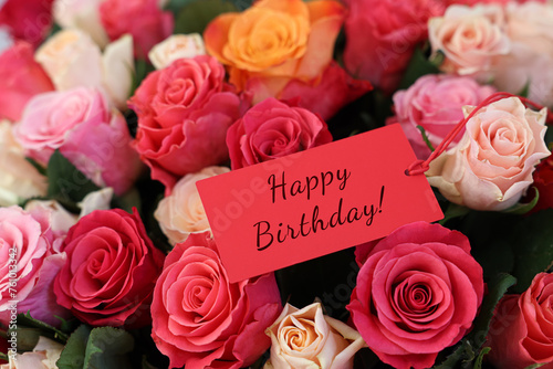 Bouquet of beautiful roses with Happy Birthday card, closeup