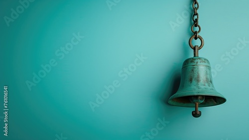 An antique bell hanging from a chain against a calming blue backdrop