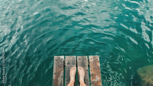 Bare feet on an old wooden dock above tranquil turquoise waters, symbolizing peace and a connection to nature © Татьяна Макарова