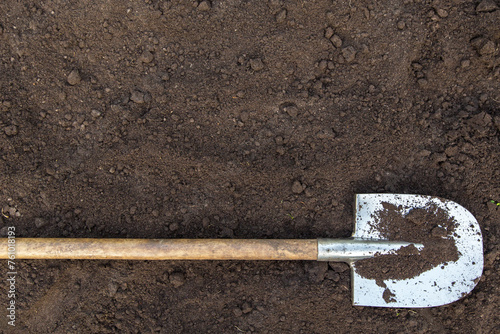 Brown dark soil ground texture background with copyspace and shovel top view. Organic farming, gardening, growing, agriculture concept photo