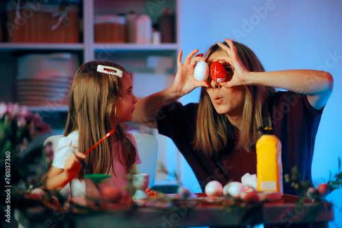 Funny Mommy Amusing her Girl with Easter Eggs as Eyes. Cheerful family having fun doing Easter related activities at home
 photo