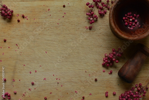 Tabla de madera lisa con pimienta rosa, pimienta rosa,  mortero de madera marrón obscuro, ramitas de pimienta rosa, alimento, natural, condimento natural, especias, hierbas  photo