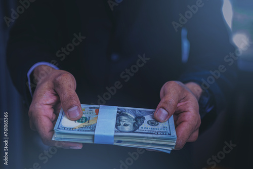 Businessman paid Dollars money banknotes and making decision for business investment. Selected focus