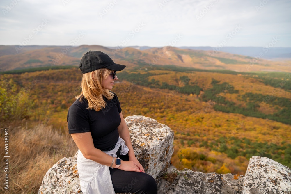 woman on mountain peak looking in beautiful mountain valley in autumn. Landscape with sporty young woman, blu sky in fall. Hiking. Nature woman on mountain peak looking in beautiful mountain valley in autumn. Landscape with sporty young woman, blu sky in fall. Hiking. Nature