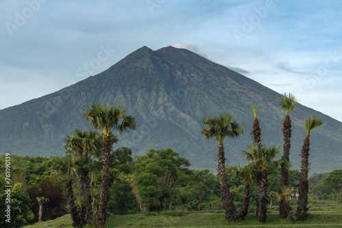 Mount Agung volcano view and tropical palm trees in rural parts of tropical Bali island, Karangasem district photo