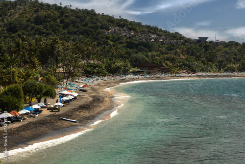 Fototapeta Naklejka Na Ścianę i Meble -  Sunny day, sand, turquoise water, blue skies, and green tropical trees at the bay of Lipah beach in Karangasem Regency, Bali island, Indonesia
