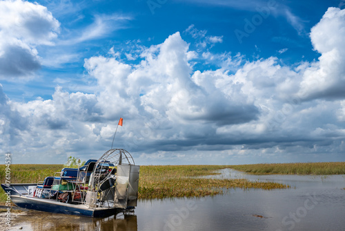 Docked airboat in the everglades of Florida with grass and wetland swamp in the background photo