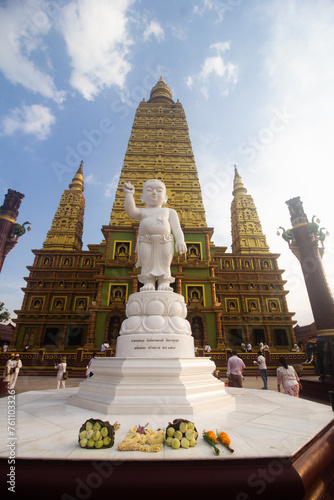 The white marble statue of the Child God in the background is the Chedi of Wat Bang Tong, Krabi Province.