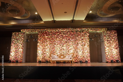 wedding backdrop. An elegantly staged traditional stage with flowers for the wedding couple to sit and receive blessings from the guests. Wedding venues and decorations for Indian wedding decors.
