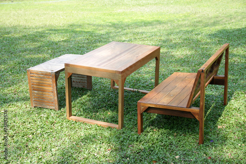 wooden set chair and table on a green meadow