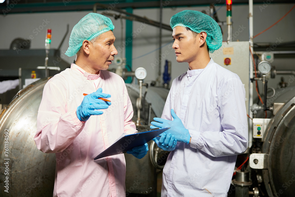 Obraz premium male workers meeting and talking about work or project in the beverage factory